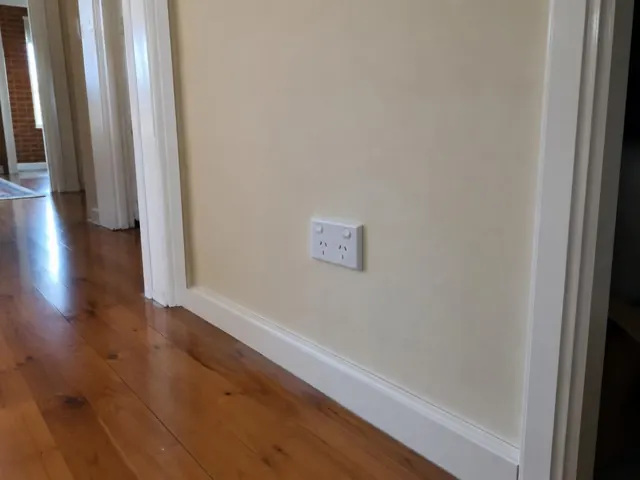 White double power point on a cream hallway wall above timber floorboards in Maryland